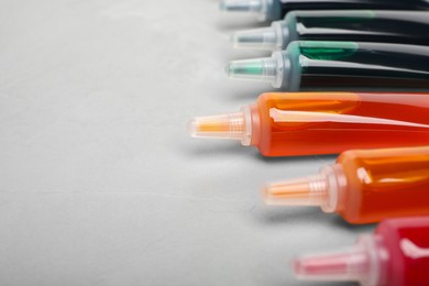 Tubes with different food coloring on white background, closeup. Space for text