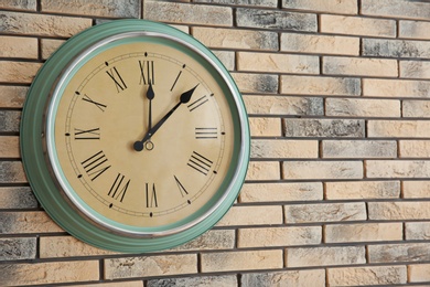 Photo of Stylish clock on brick wall. Time concept