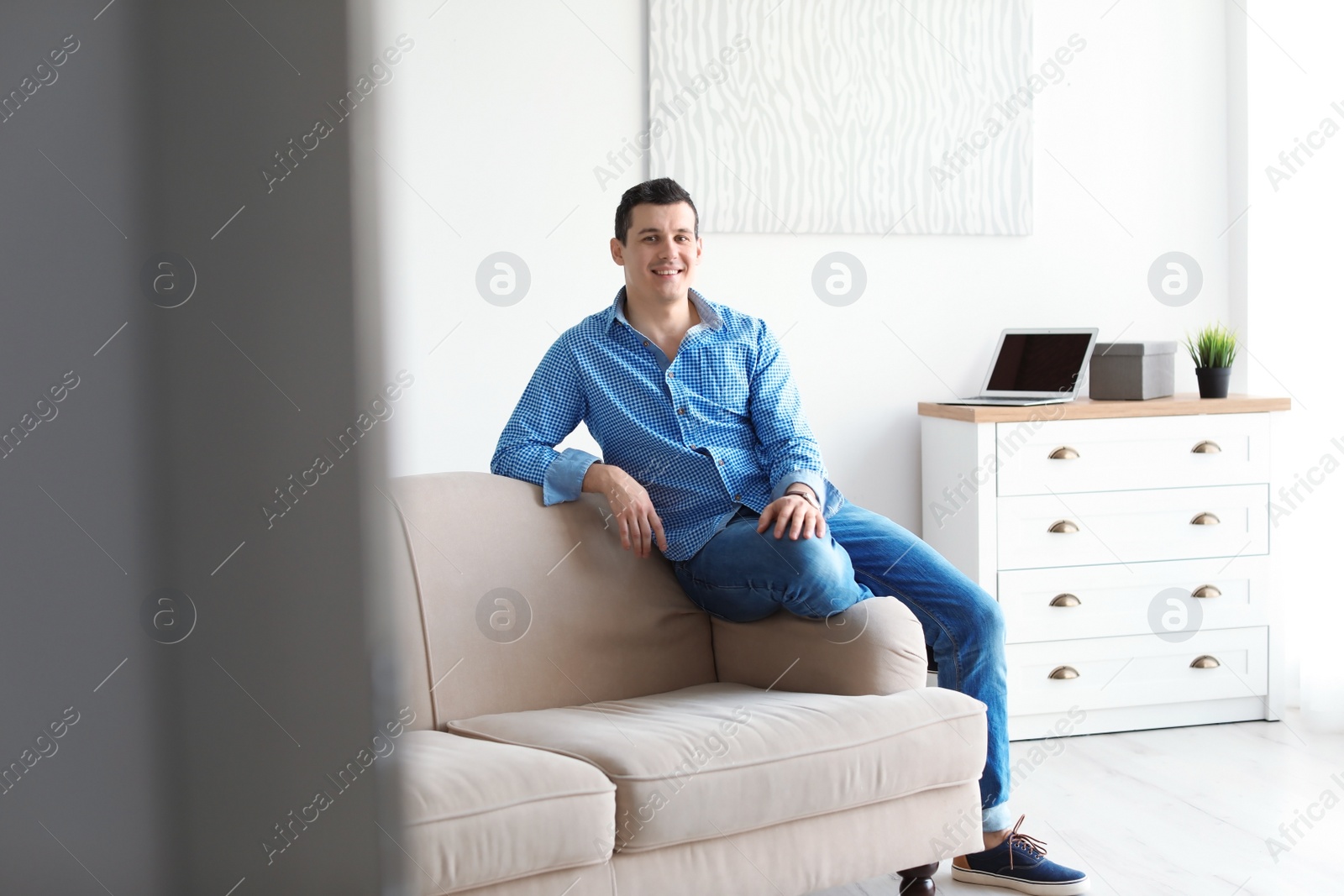 Photo of Portrait of confident man on sofa at home