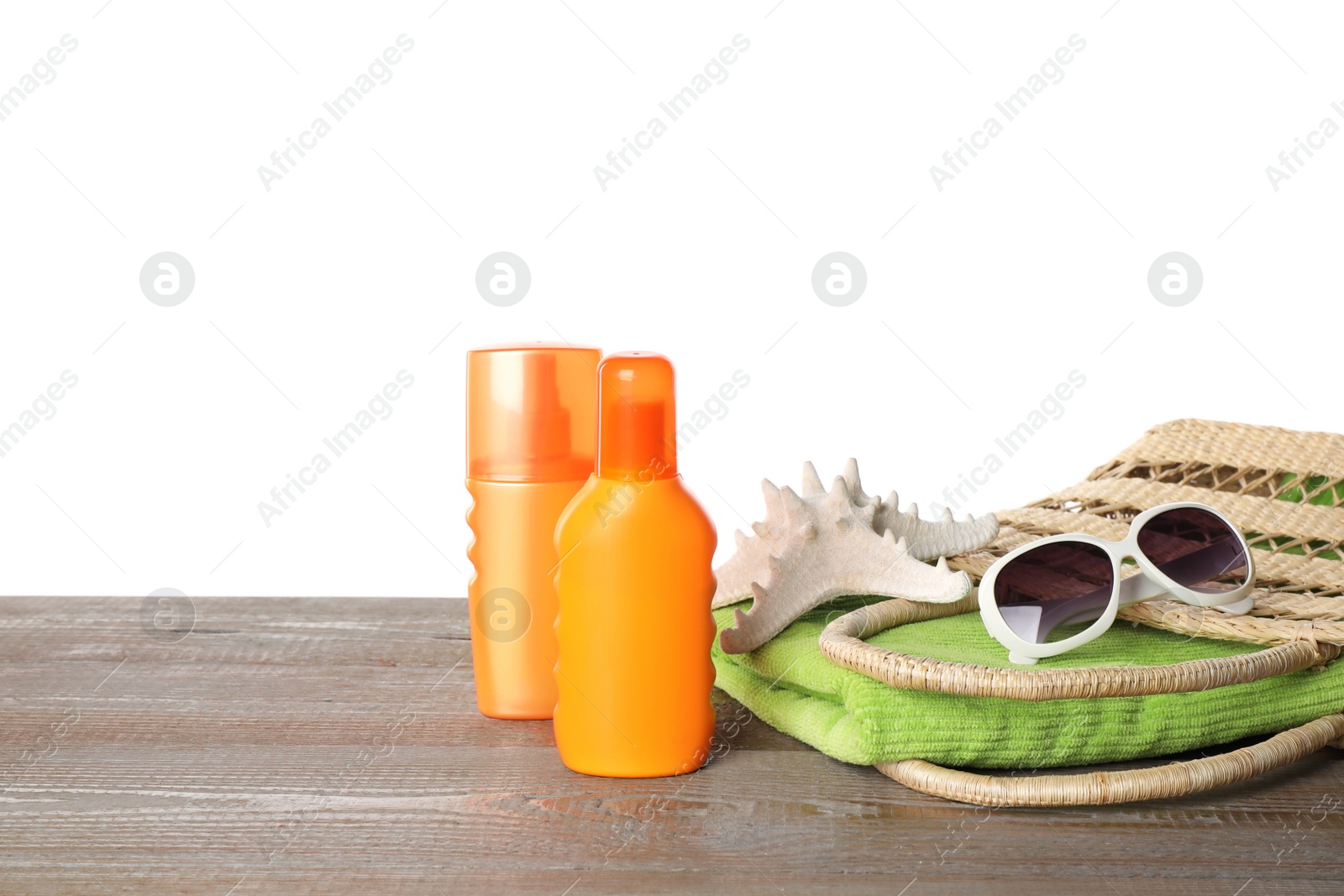 Photo of Sun protection products and beach accessories on wooden table against white background