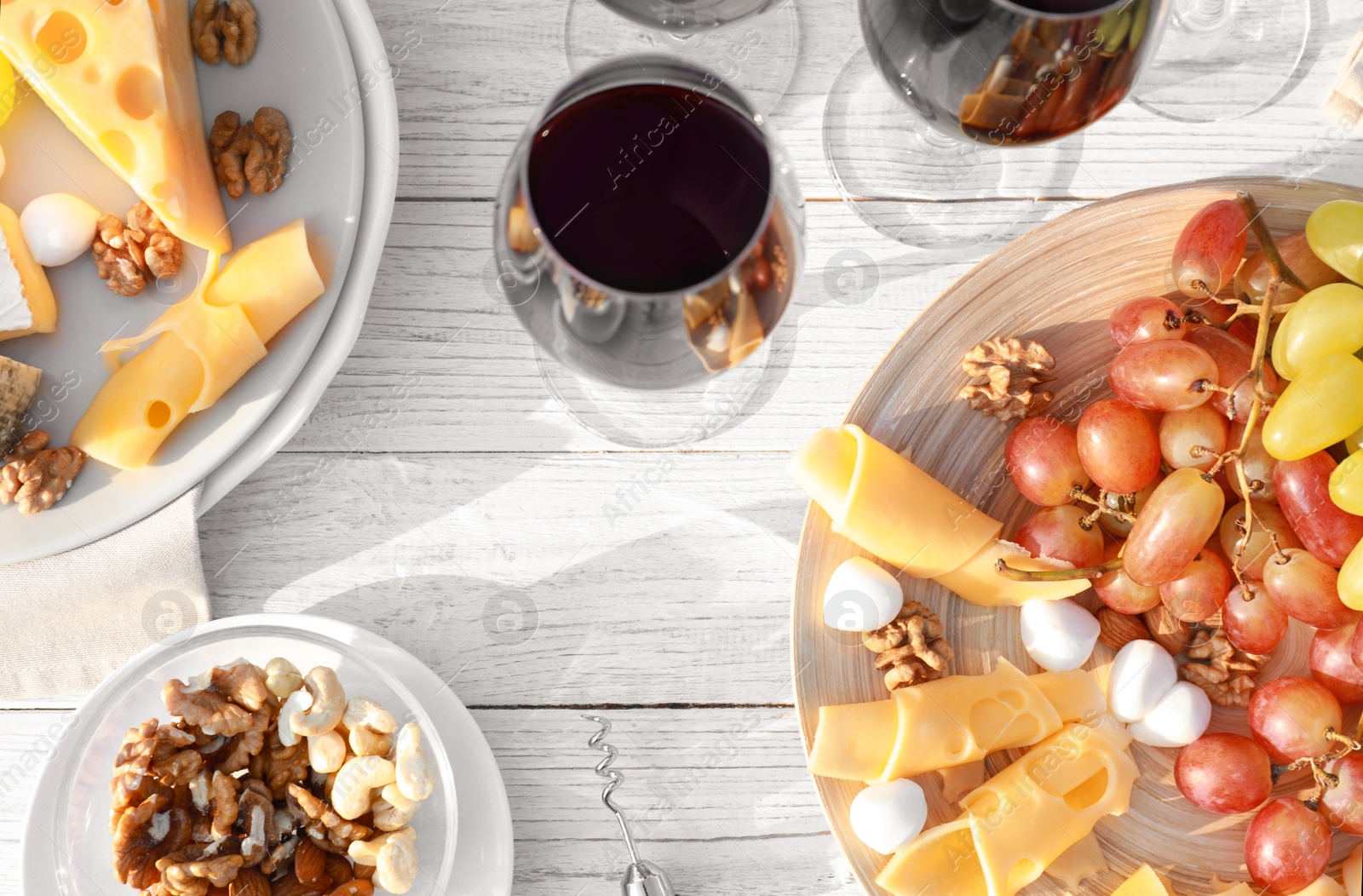 Photo of Flat lay composition with red wine and snacks on white wooden table