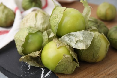 Fresh green tomatillos with husk on table, closeup