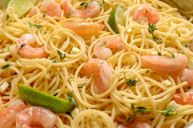Photo of Delicious spaghetti with shrimps and lime, closeup