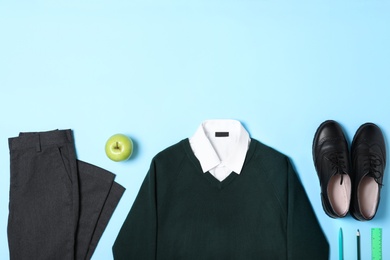 Photo of Flat lay composition with school uniform on blue background. Space for text