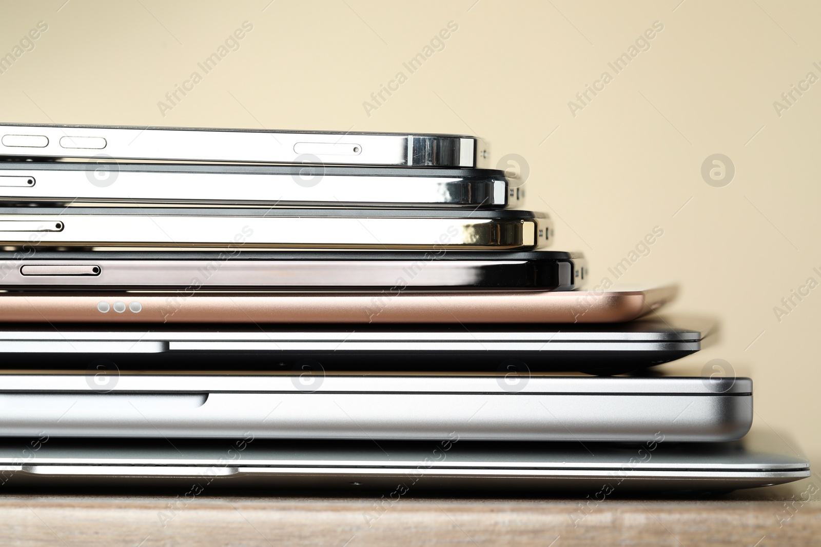 Photo of Stack of electronic devices on wooden table, closeup