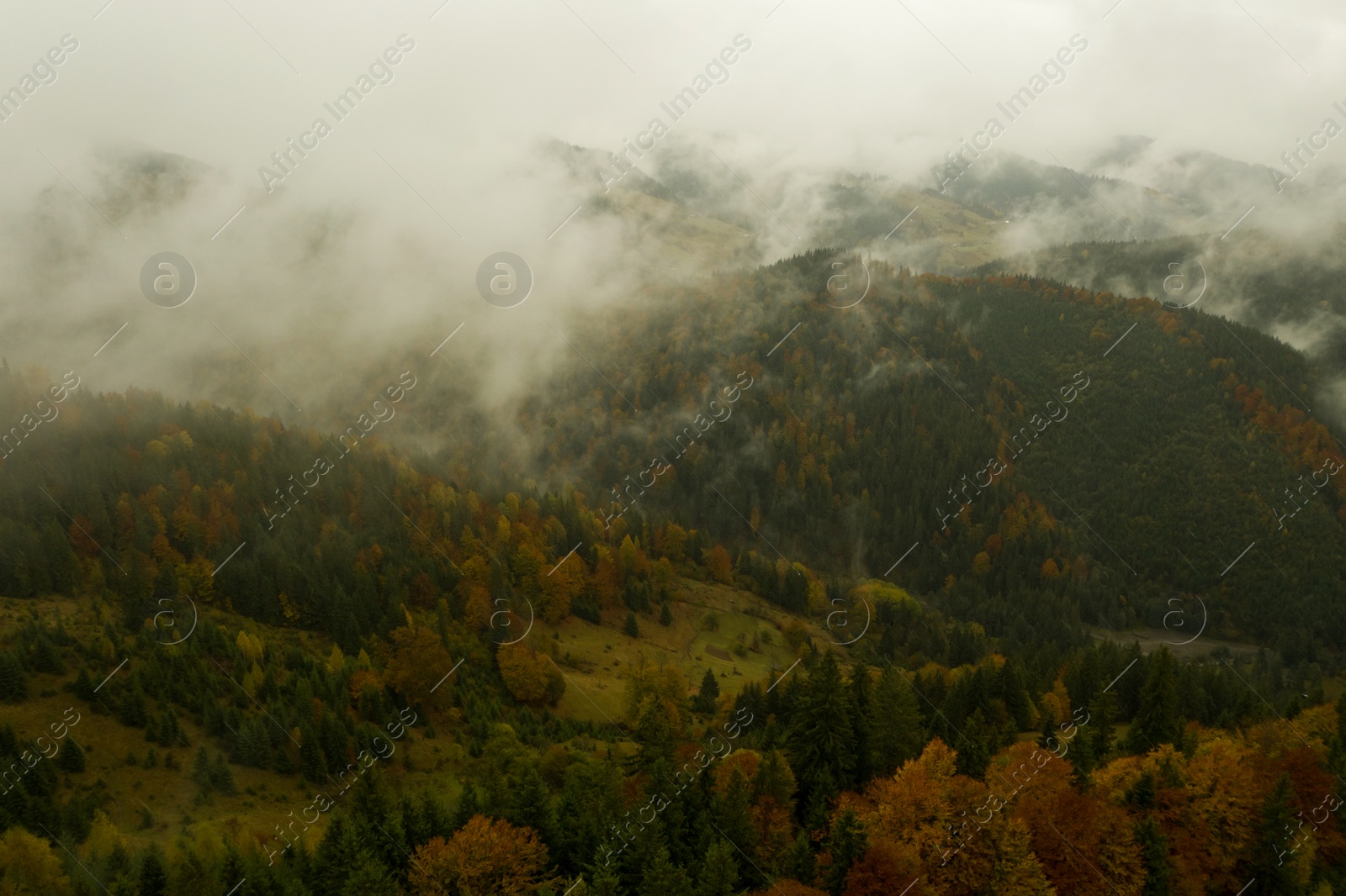 Image of Aerial view of mountains covered with fog