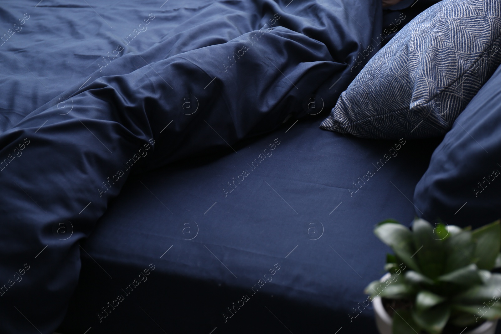 Photo of Bed with stylish silky linens in room