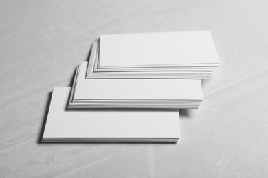 Photo of Blank business cards on light grey textured table, closeup. Mockup for design