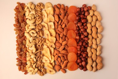 Photo of Mix of delicious dried nuts and fruits on beige background, flat lay