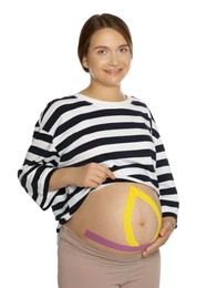 Pregnant woman with kinesio tapes on her belly against white background