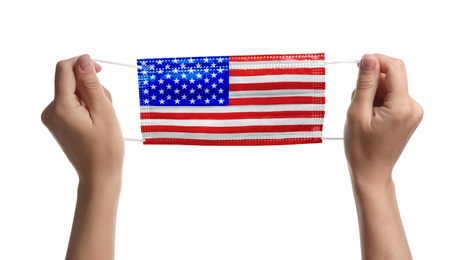 Image of Woman holding medical mask with USA flag pattern on white background, closeup. Dangerous virus