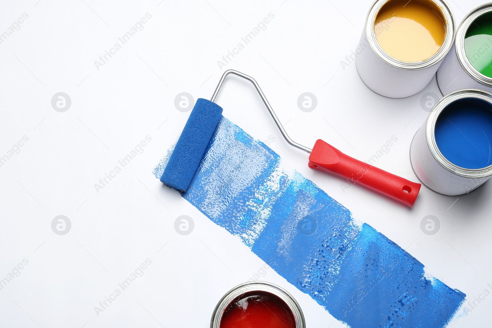 Photo of Composition with paint cans and roller brush on white background