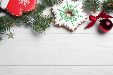 Flat lay composition with tasty homemade Christmas cookies on white wooden table, space for text