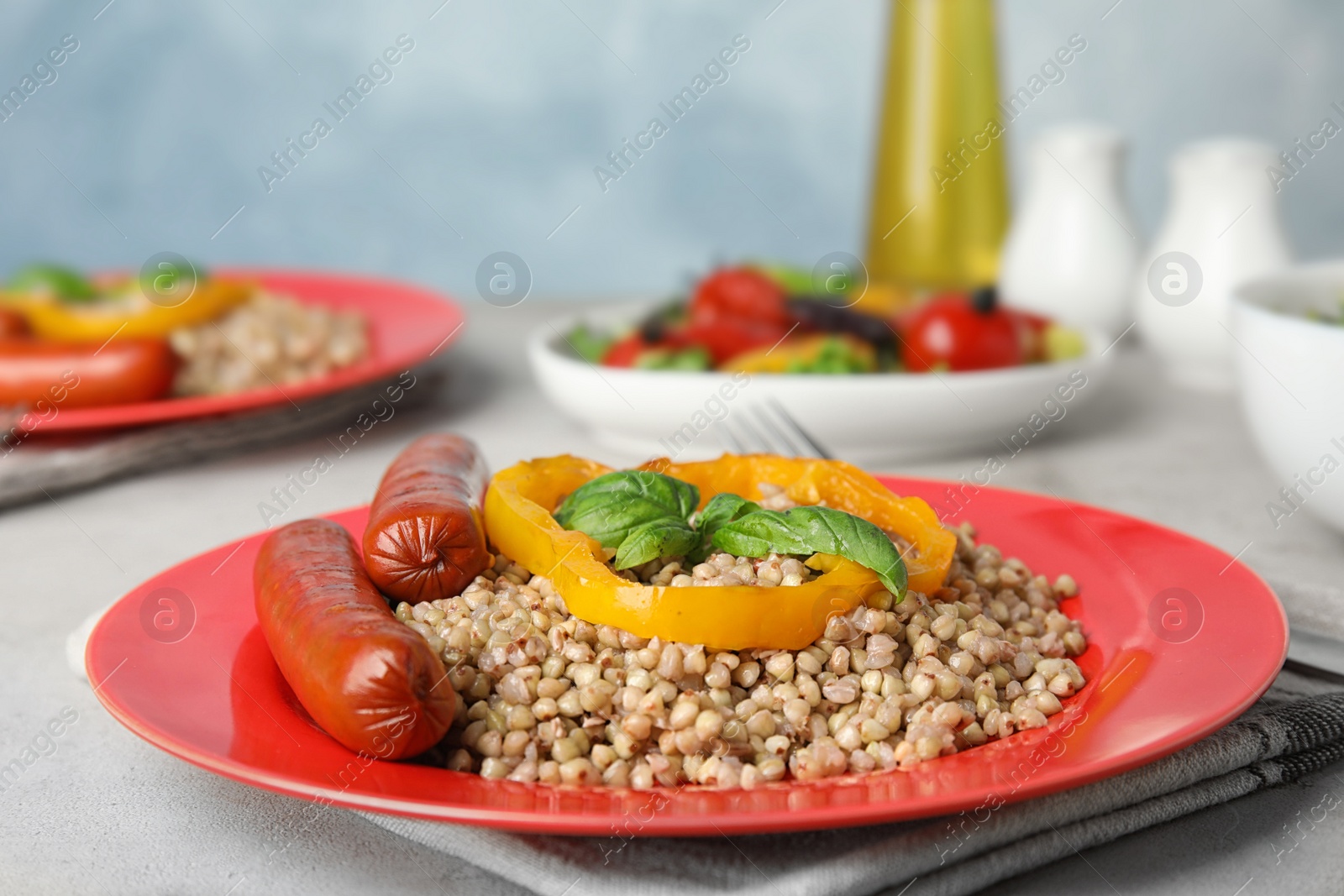 Photo of Tasty buckwheat porridge with sausages on light table. Space for text