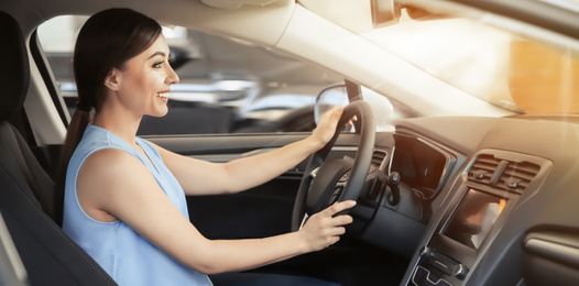 Image of Happy young woman driving modern car on sunny day. Banner design