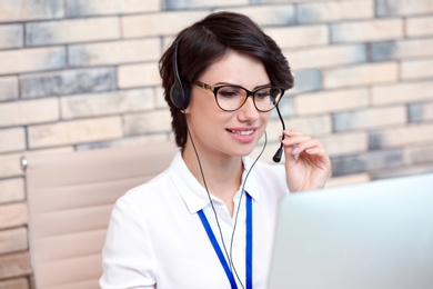 Female technical support operator with headset at workplace