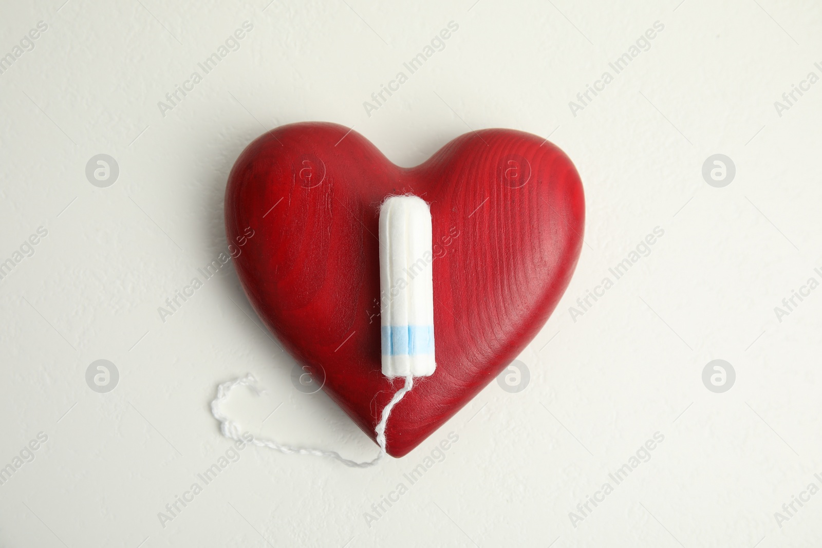 Photo of Tampon and red heart on white background, flat lay