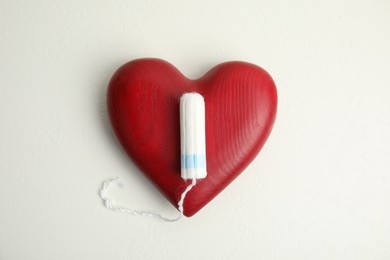 Tampon and red heart on white background, flat lay