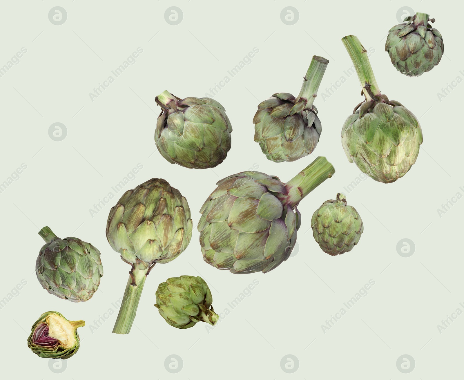 Image of Fresh raw artichokes falling on color background