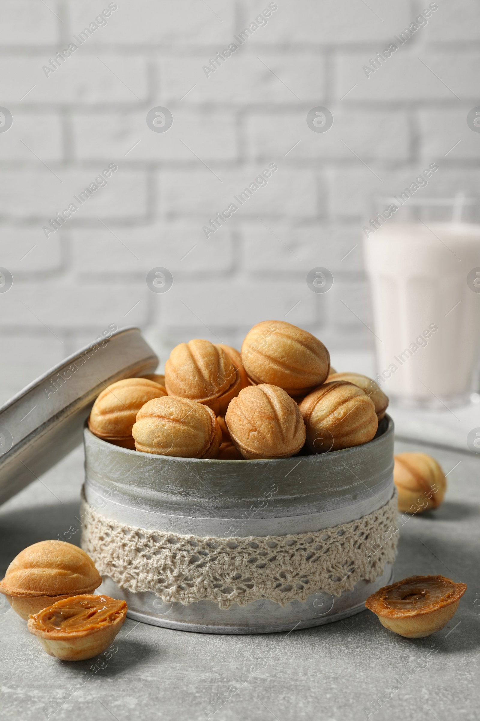 Photo of Delicious nut shaped cookies with boiled condensed milk on light grey table