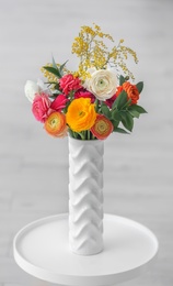 Photo of Vase with beautiful ranunculus flowers indoors