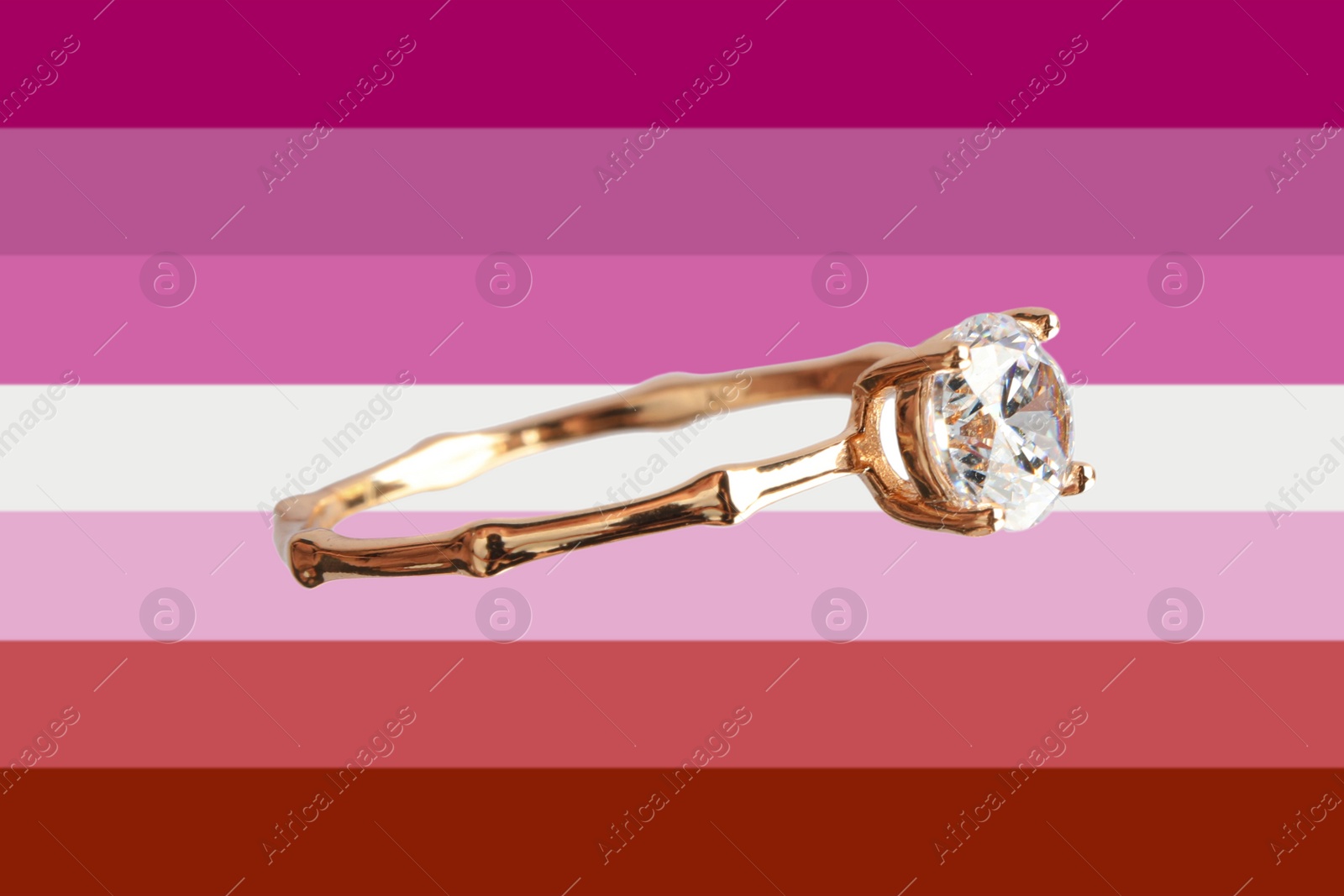 Image of Beautiful engagement ring on background in color of lesbian flag
