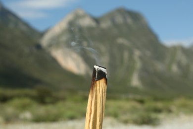 Burning palo santo stick in high mountains, closeup