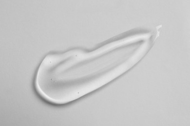 Photo of Smear of cosmetic oil on white background, top view
