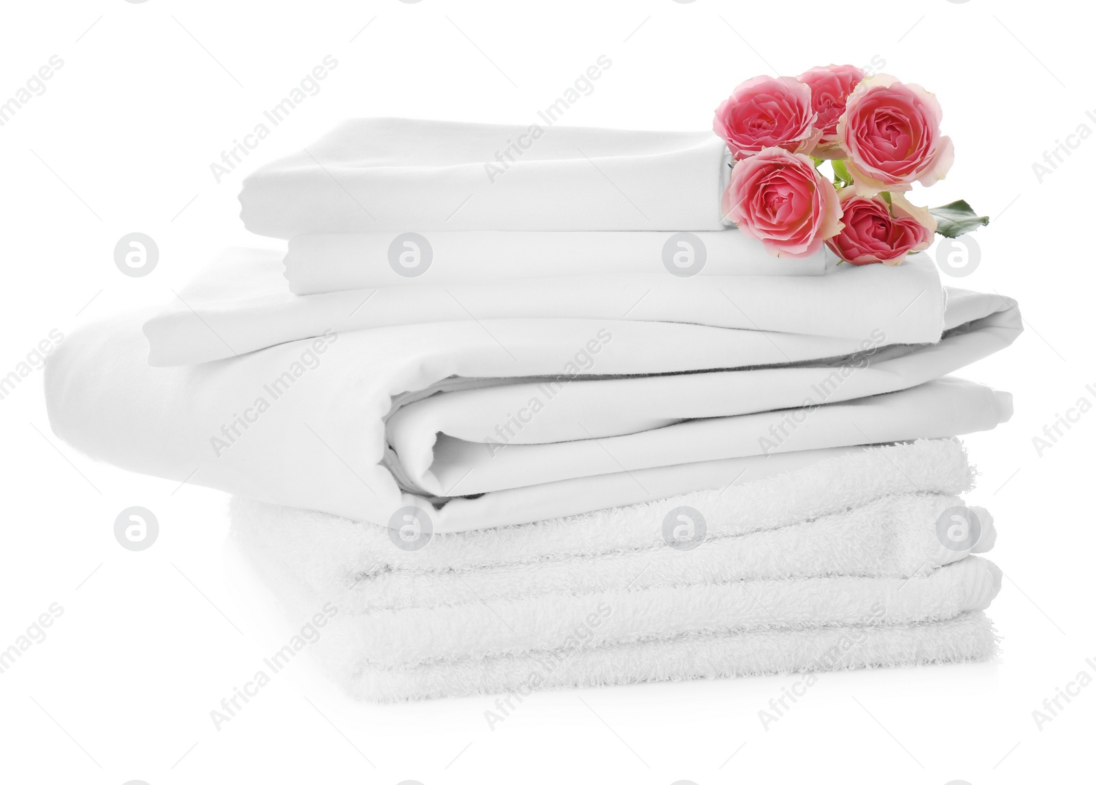 Photo of Stack of towels and bed sheets with roses on white background
