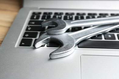 Photo of Laptop and spanners on table, closeup. Concept of technical support