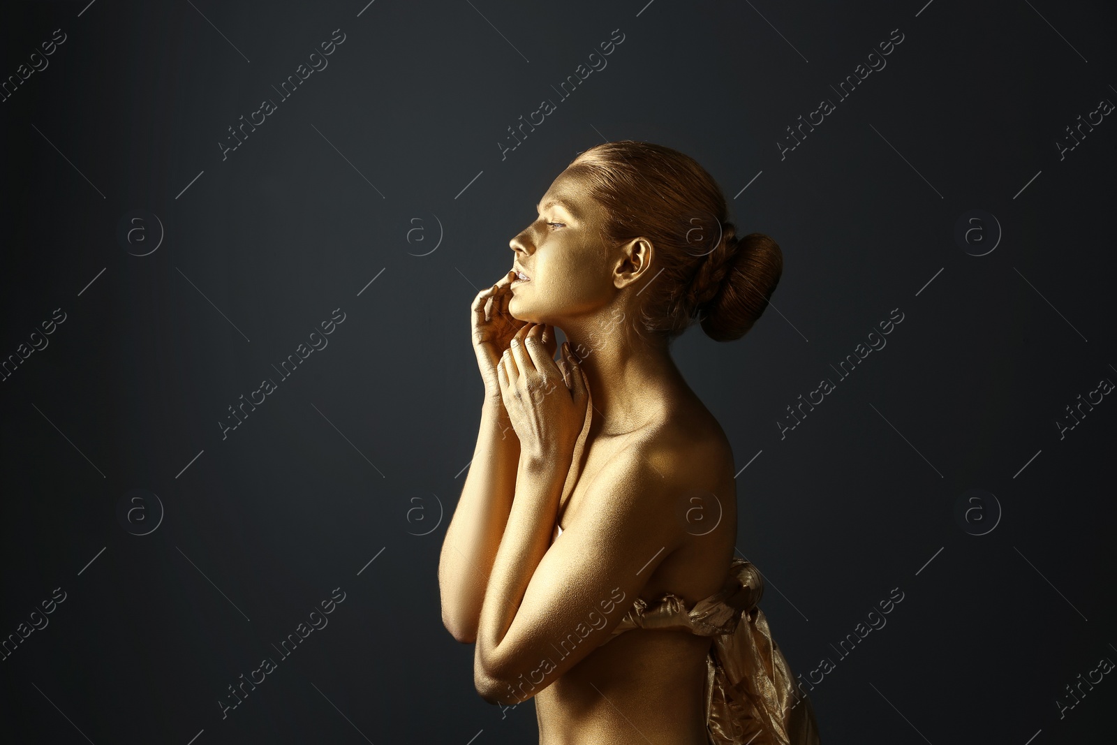 Photo of Portrait of beautiful lady with gold paint on skin against grey background