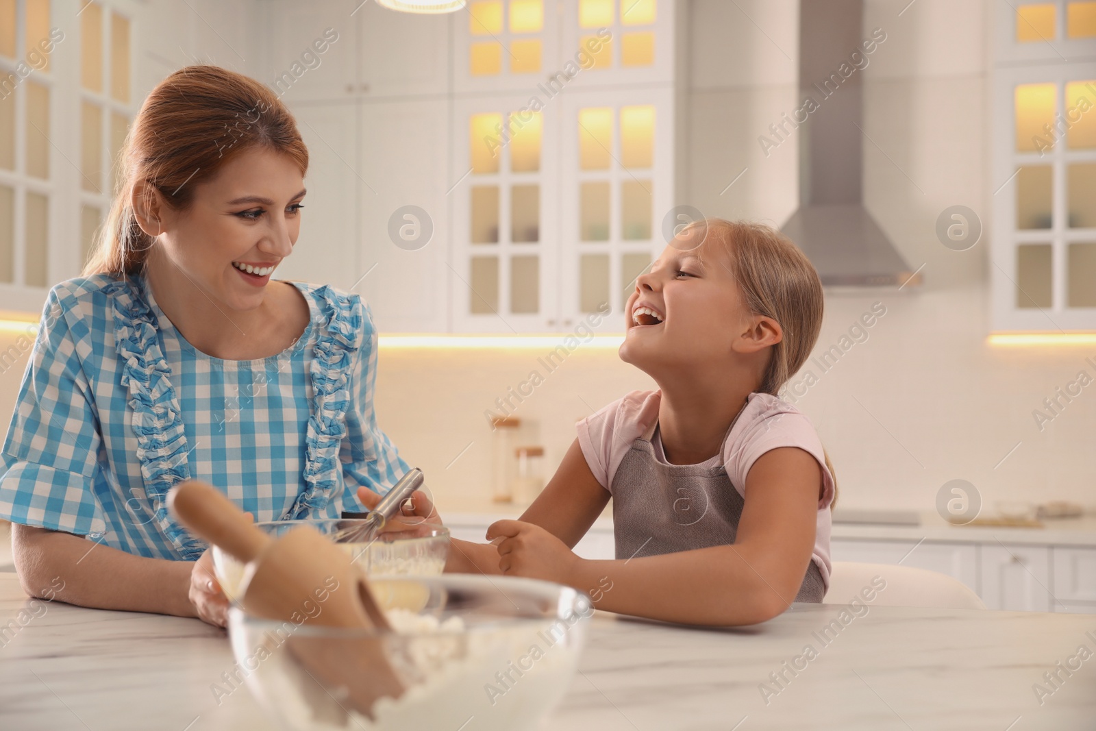 Photo of Mother and daughter making dough together in kitchen