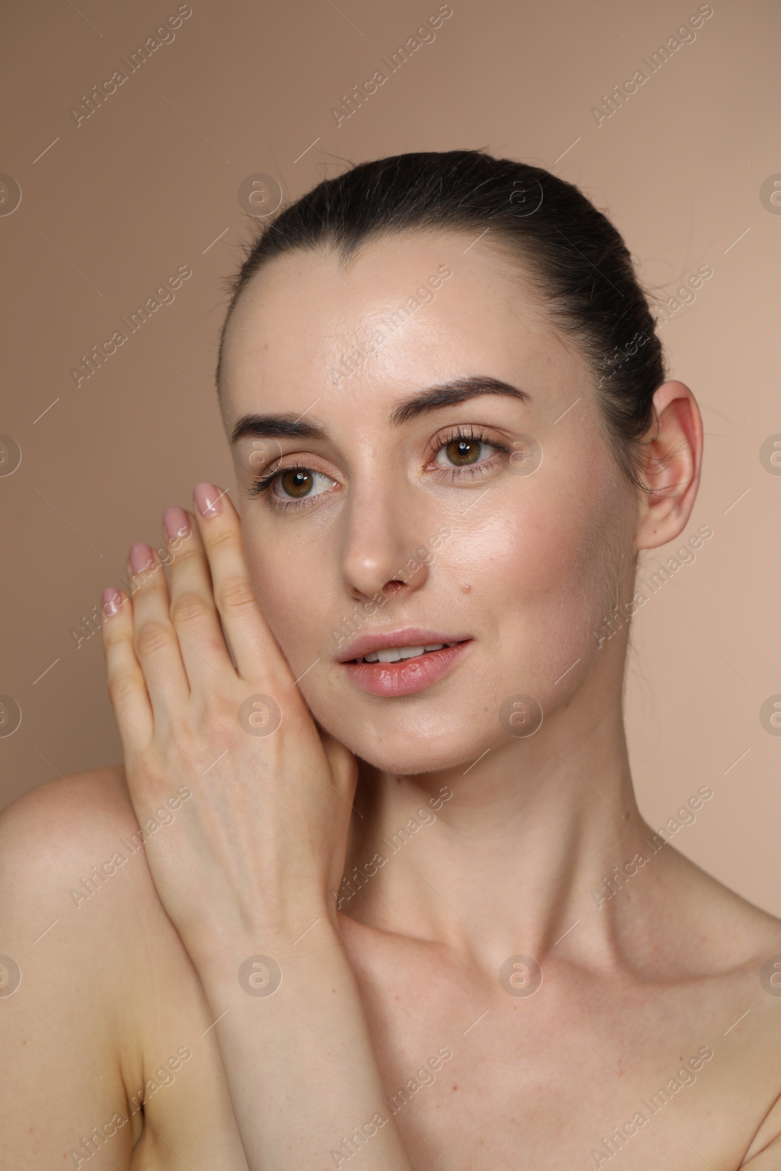 Photo of Portrait of beautiful young woman on light brown background