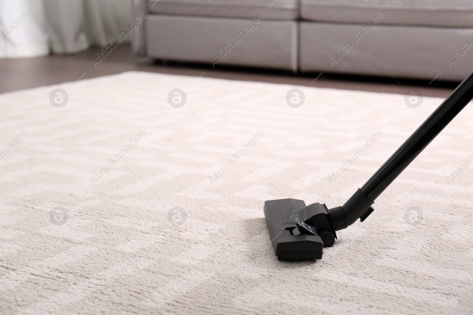 Photo of Hoovering floor with modern vacuum cleaner, closeup. Space for text