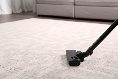 Hoovering floor with modern vacuum cleaner, closeup. Space for text