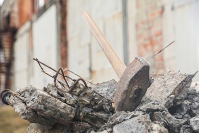 Photo of Sledgehammer on pile of broken stones outdoors, closeup