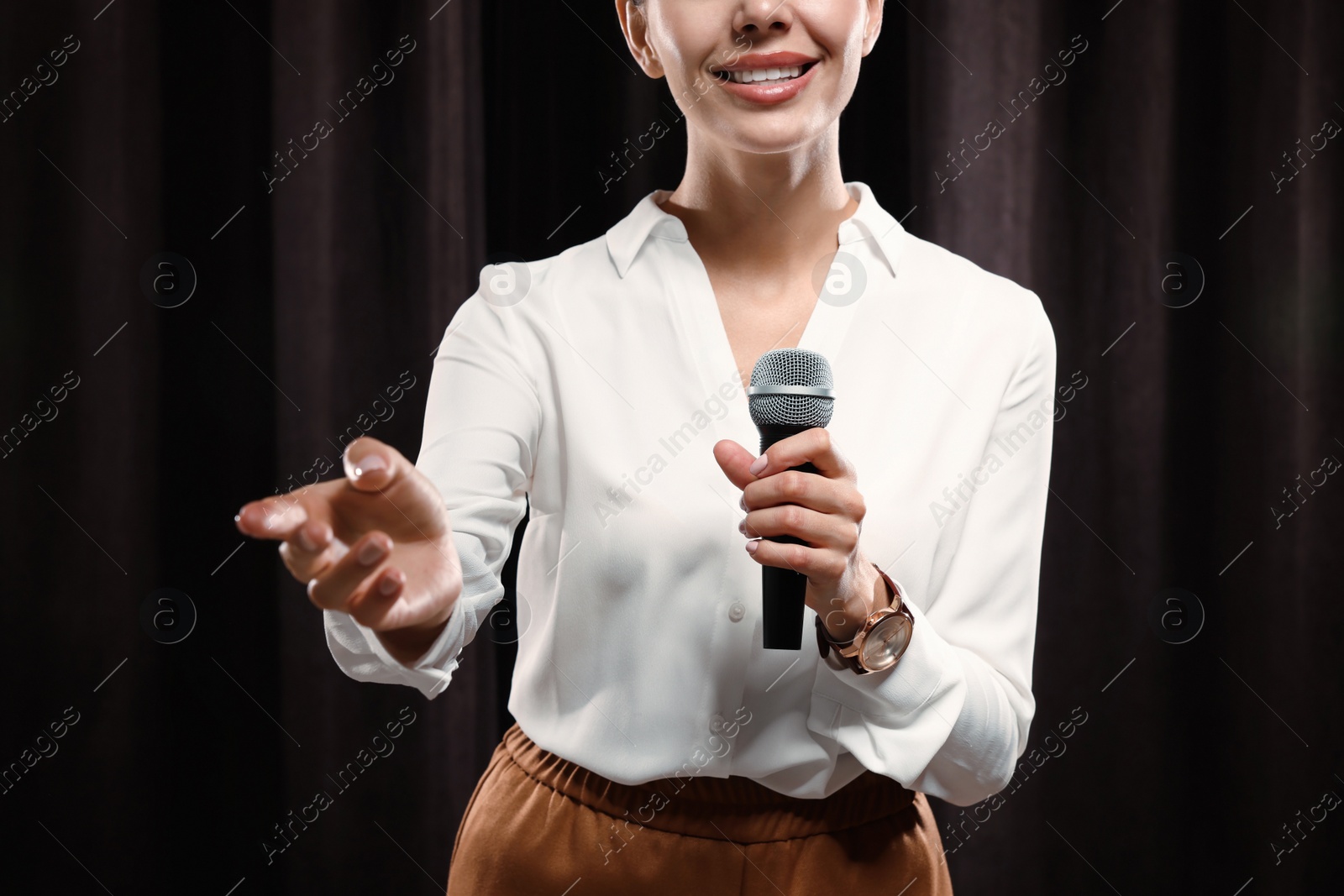 Photo of Motivational speaker with microphone performing on stage, closeup 