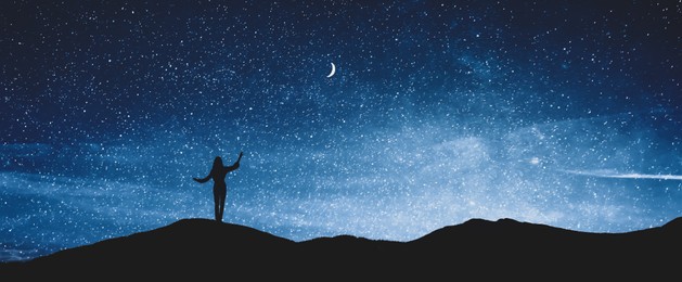 Image of Silhouette of woman in mountains under starry sky at night, space for text. Banner design