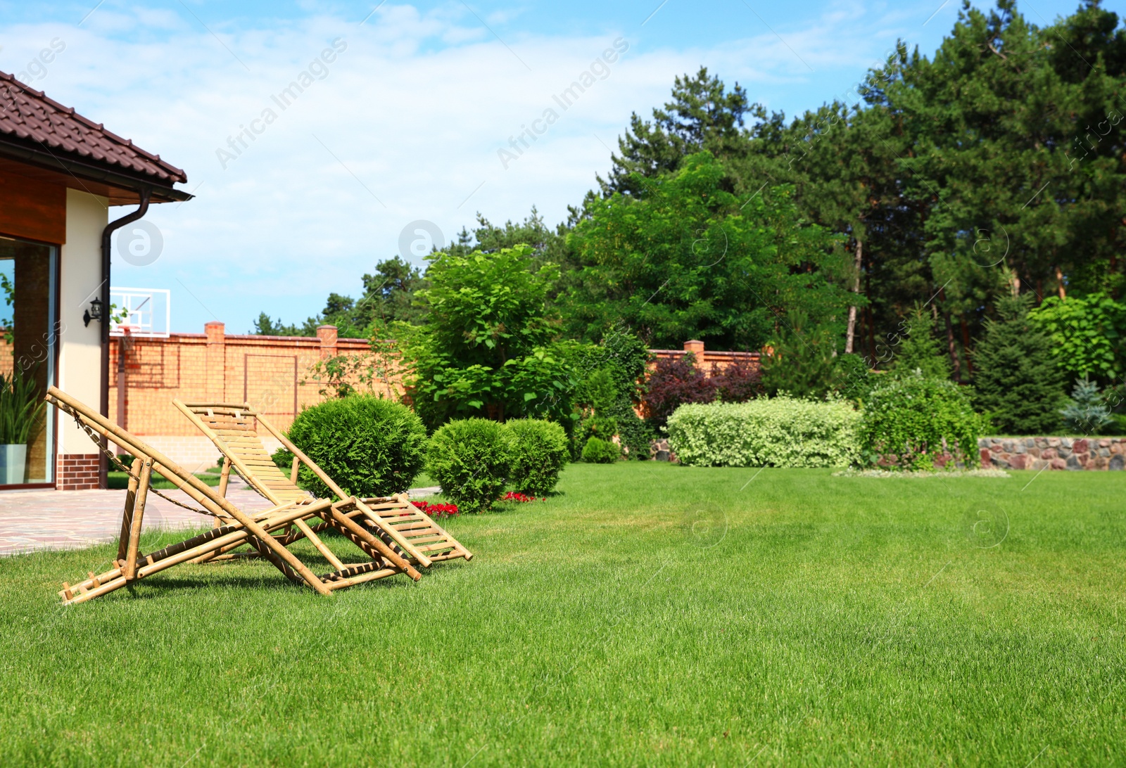 Photo of Wooden deck chairs in garden on sunny day