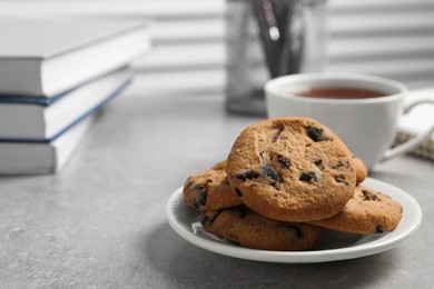 Photo of Chocolate chip cookie on light grey table in office, closeup. Space for text