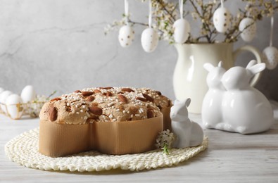 Photo of Delicious Italian Easter dove cake (Colomba di Pasqua) and festive decor on white wooden table