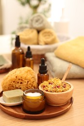 Dry flowers, loofah, soap bar, bottle of essential oil and jar with cream on wooden table indoors, space for text. Spa time