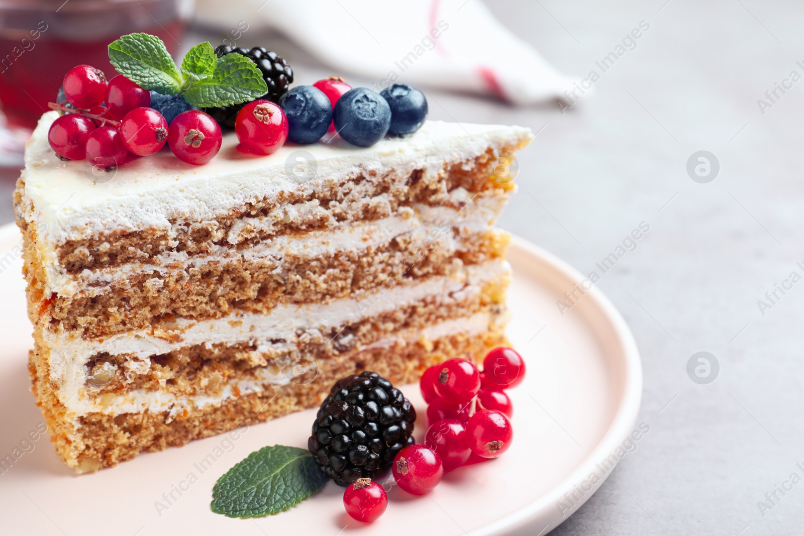 Photo of Tasty cake with berries on grey table, closeup