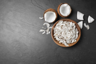 Photo of Flat lay composition with tasty coconut chips on black  table. Space for text