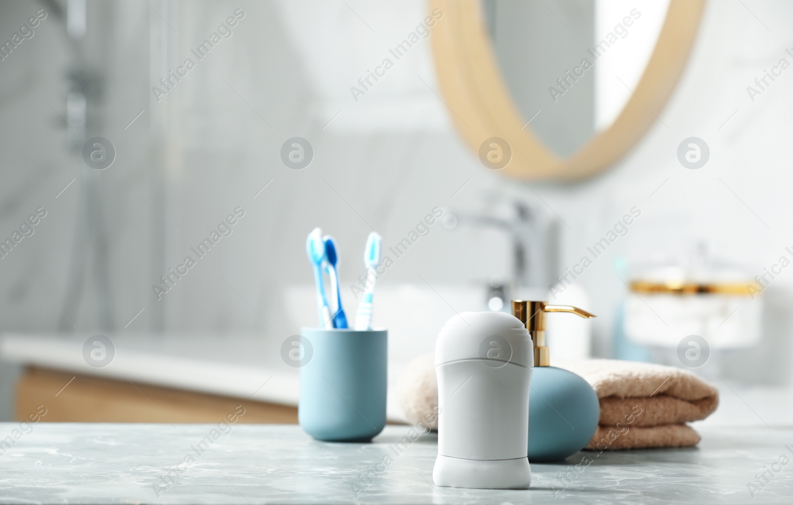 Photo of Stick deodorant and different toiletry on table in bathroom, space for text