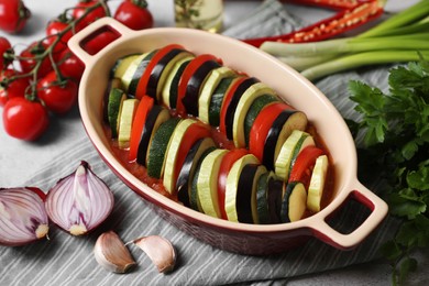 Cooking delicious ratatouille. Dish with different cut vegetables on table, closeup