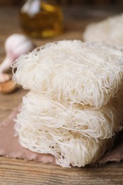 Uncooked rice noodles on wooden table, closeup
