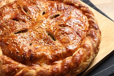 Photo of Tasty homemade pie with filling on wooden table, closeup