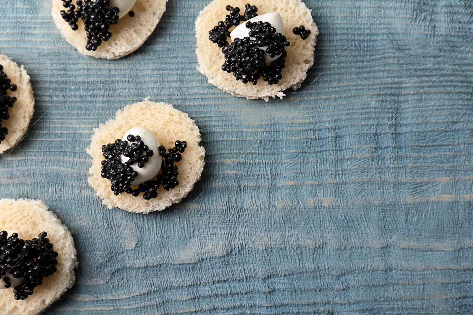 Photo of Sandwiches with black caviar and cheese on wooden background