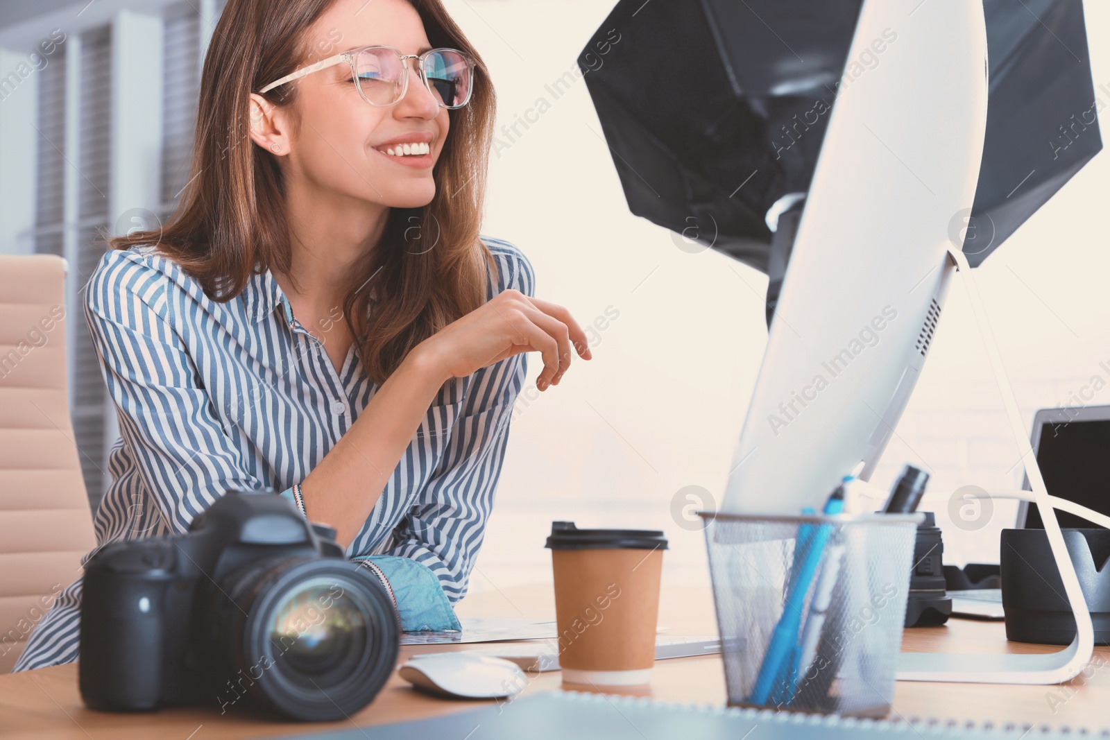 Image of Professional photographer working at table in office
